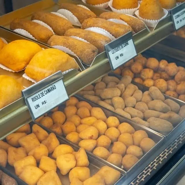 Vitrine da Vilamore cheia de salgados dourados, com as etiquetas de cada sabor.